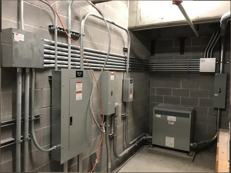 Industrial electrical room with multiple panels and conduit runs